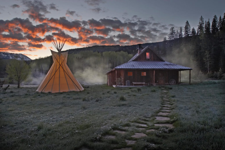 Tipi and bathhouse cabin at dawn