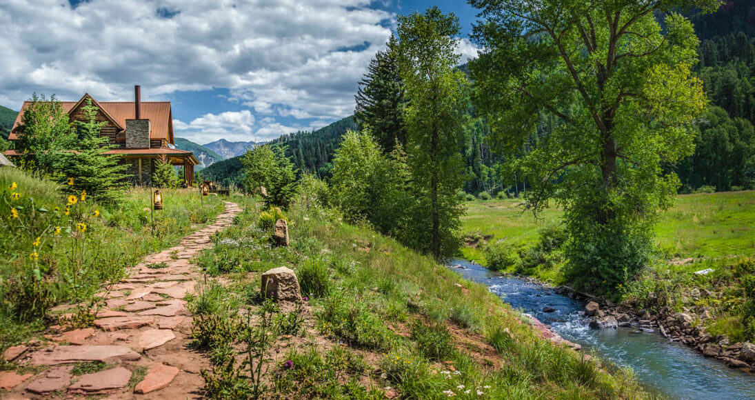 Cabin in front of river and Colorado mountain landscape